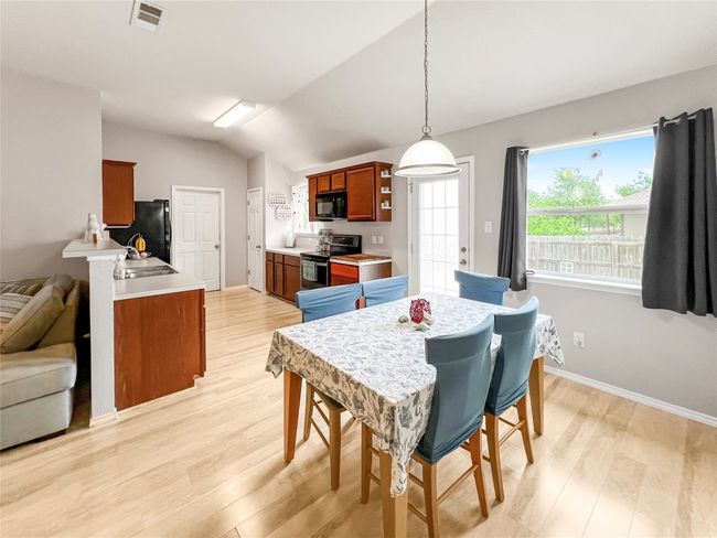 Dining area featuring light wood-type flooring, vaulted ceiling, and baseboards | Image 8
