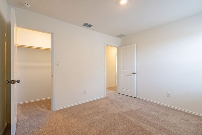 Unfurnished bedroom featuring carpet floors, a spacious closet, baseboards, and a closet | Image 20