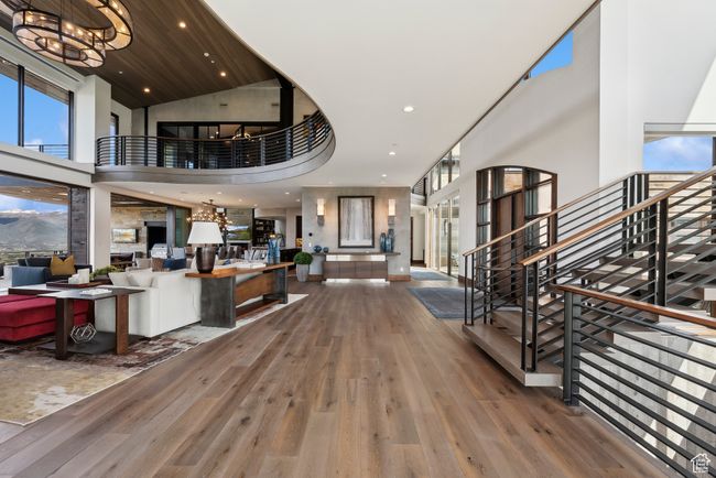 Foyer entrance featuring a high ceiling, wood-type flooring, stairway, a chandelier, and recessed lighting | Image 40
