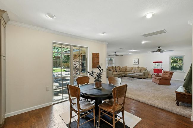 Dining space with ornamental molding, a ceiling fan, healthy amount of natural light, and wood finished floors | Image 14