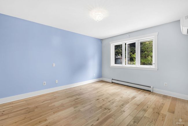 Empty room featuring baseboard heating, light wood finished floors, baseboards, and a wall mounted AC | Image 24