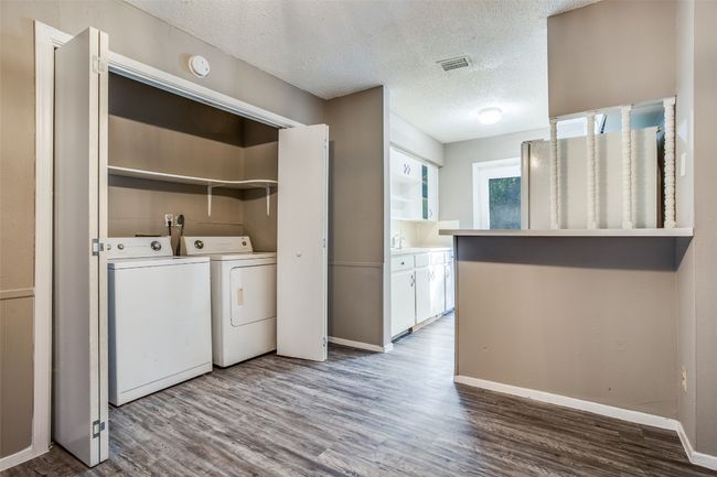 Laundry area featuring laundry area, a textured ceiling, baseboards, wood finished floors, and washer and clothes dryer | Image 15