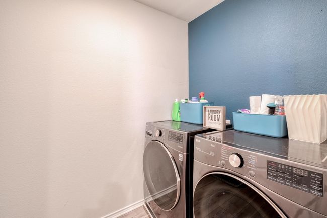 Clothes washing area with baseboards, washer and dryer, wood finished floors, and laundry area | Image 29