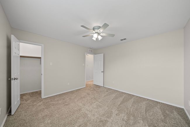 Unfurnished bedroom with carpet flooring, a walk in closet, and ceiling fan | Image 36