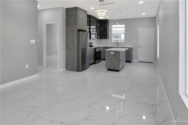Kitchen featuring light countertops, appliances with stainless steel finishes, a center island, modern cabinets, and recessed lighting | Image 5