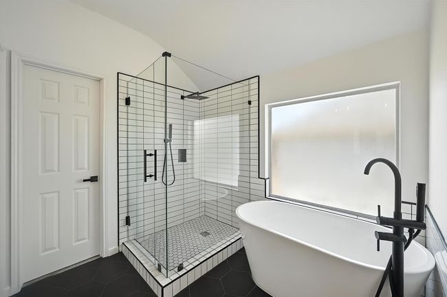 Full bathroom featuring a shower stall, a soaking tub, lofted ceiling, and tile patterned flooring | Image 13