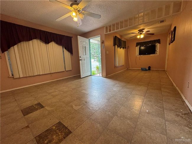Unfurnished room with ceiling fan, baseboards, and a textured ceiling | Image 7
