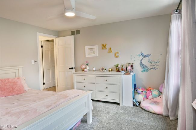 Bedroom with ceiling fan, carpet, and visible vents | Image 42