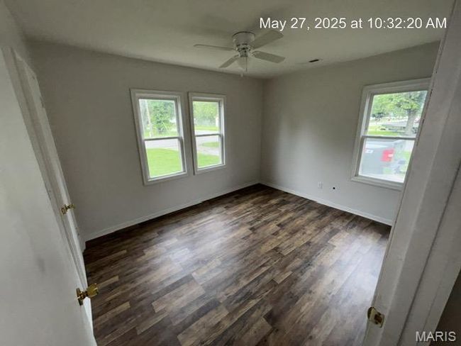 Empty room featuring healthy amount of natural light, dark wood finished floors, a ceiling fan, and baseboards | Image 10