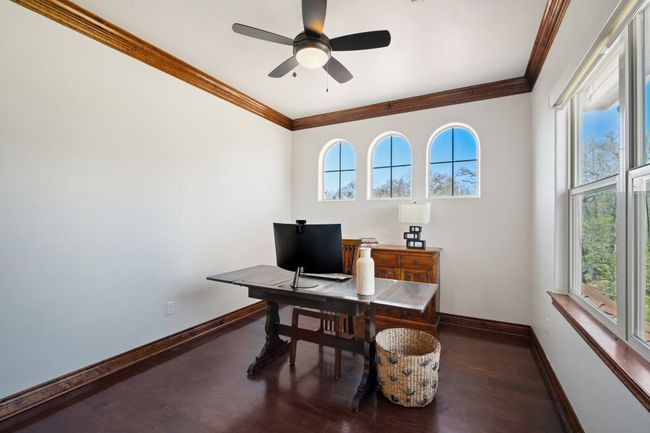Office area with baseboards, a ceiling fan, wood finished floors, and crown molding | Image 26