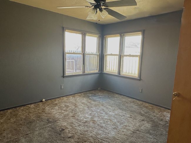 Spare room with a wealth of natural light, carpet flooring, and a ceiling fan | Image 6