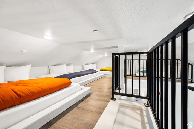 Bedroom with vaulted ceiling and light wood-type flooring | Image 38