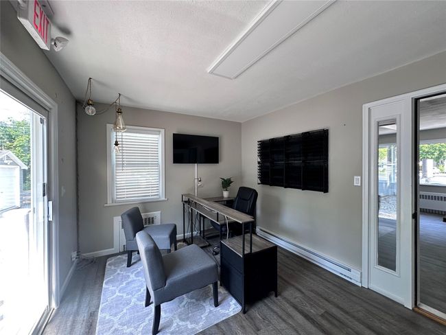 Office featuring a baseboard heating unit, radiator, wood finished floors, and plenty of natural light | Image 23