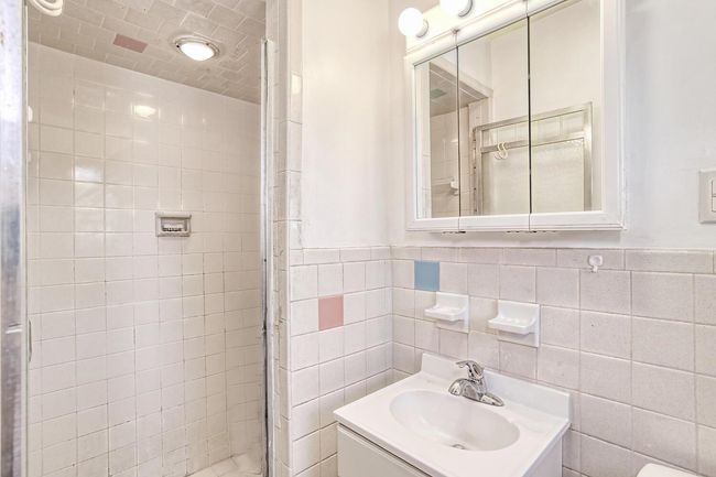 Bathroom with vanity, a stall shower, and wainscoting | Image 18