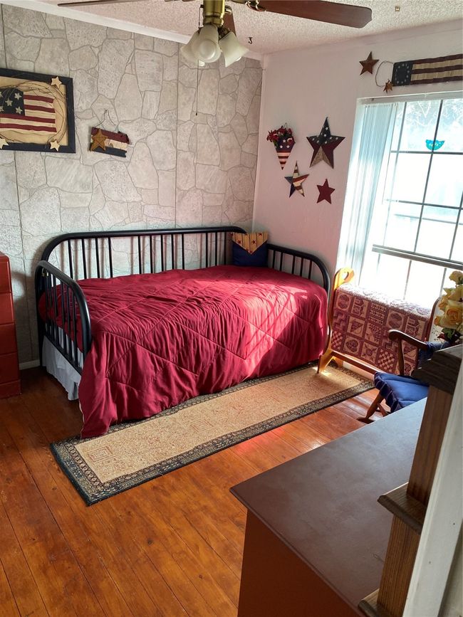 Bedroom featuring hardwood / wood-style flooring, ceiling fan, and a textured ceiling | Image 17