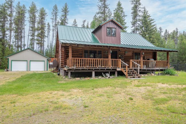 Cabin featuring log siding, a detached garage, a front yard, a standing seam roof, and an outbuilding | Image 20