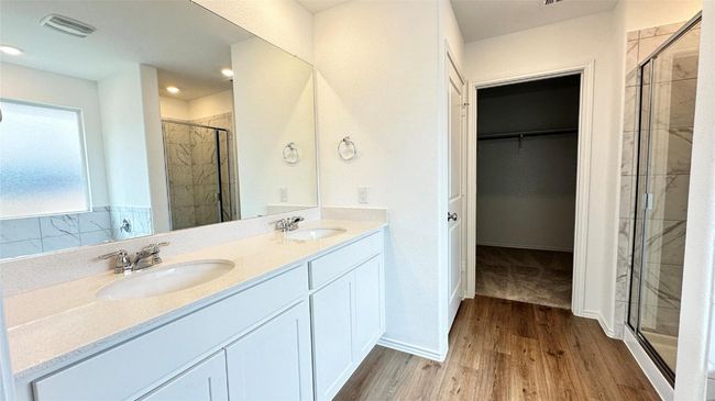 Full bathroom with a spacious closet, a shower stall, a sink, and visible vents | Image 20