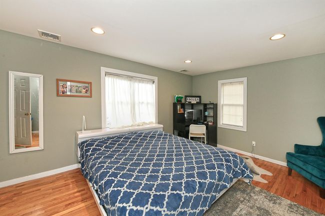 Bedroom with baseboards, visible vents, and wood finished floors | Image 5