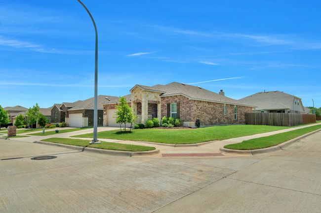 Ranch-style house featuring a garage, driveway, brick siding, a residential view, and stone siding | Image 4