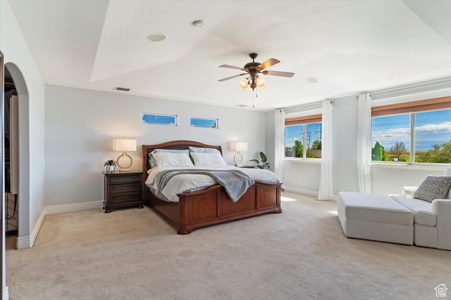 Bedroom featuring arched walkways, light colored carpet, visible vents, and baseboards | Image 33