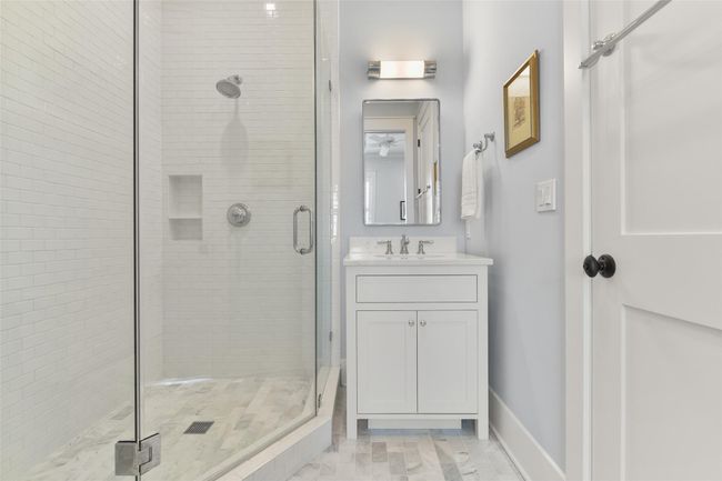 Charming guest bathroom with a marble floors and walk-in shower. | Image 22