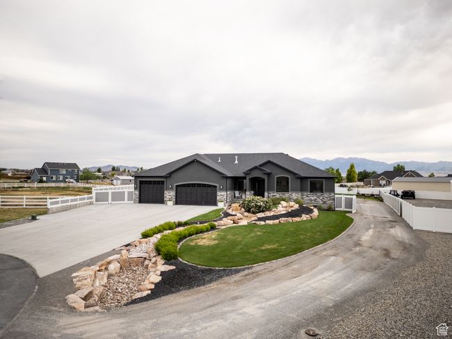Ranch-style house with driveway, a garage, a mountain view, stone siding, and stucco siding | Image 10