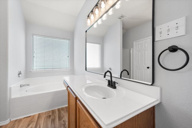 Full bath featuring vanity, new laminate flooring, and a garden tub | Image 27