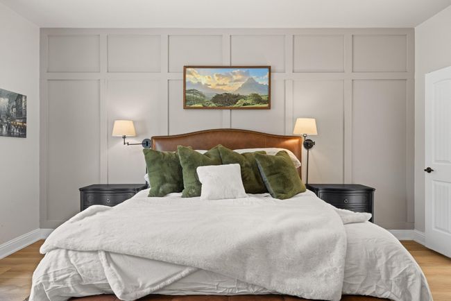 Bedroom with light wood-type flooring, baseboards, and a decorative wall | Image 7