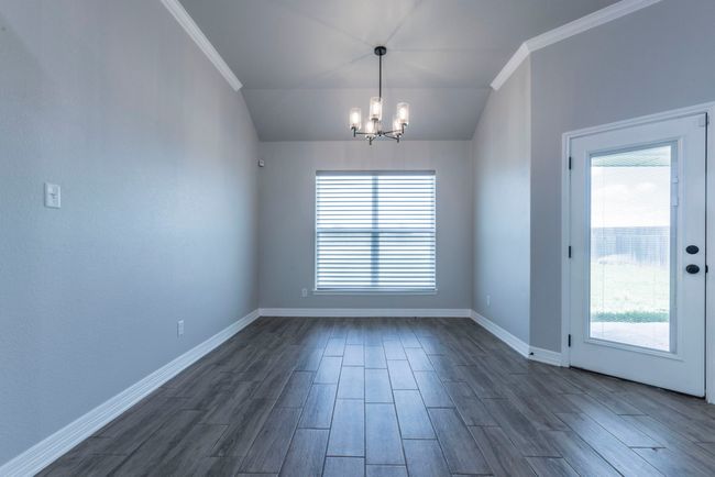 Eating area , dark finished floors, lofted ceiling, and crown molding | Image 11