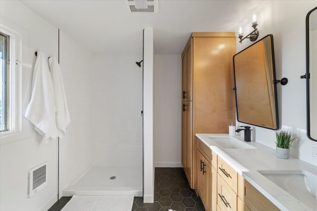 Bathroom featuring tile patterned flooring, vanity, and a shower | Image 26