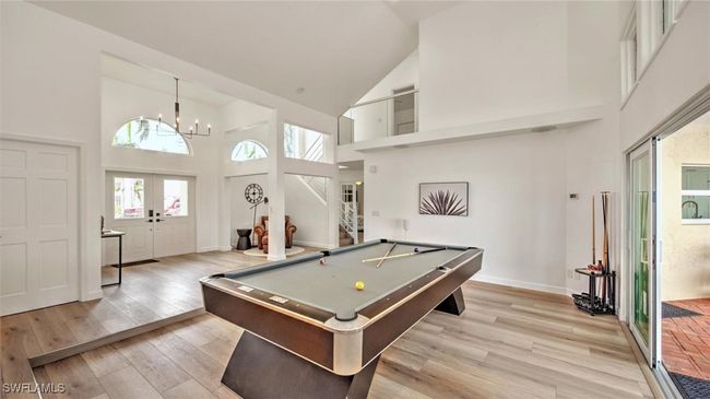 Recreation room featuring high vaulted ceiling, a chandelier, billiards, and light wood finished floors | Image 10