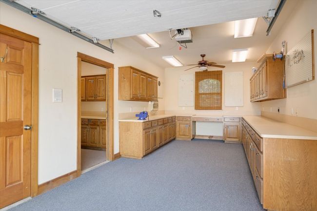 This workshop has a bay door, a 1/2 bath, a window AC unit and a window. It adjoins the other workshop and the 2 additional garage spaces. Lots of lighting! | Image 32