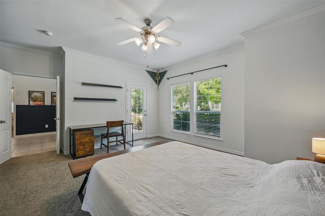 Bedroom featuring crown molding, access to exterior, carpet flooring, ceiling fan, and baseboards | Image 17