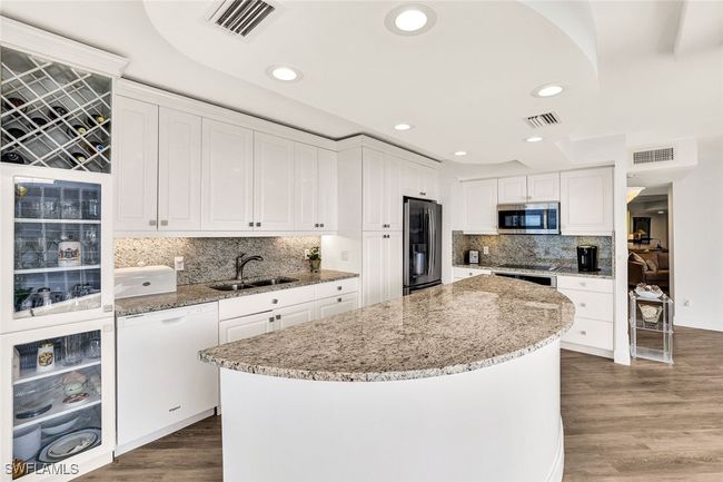 Kitchen featuring appliances with stainless steel finishes, a sink, visible vents, and a kitchen island | Image 14