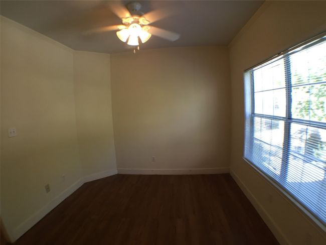 Empty room with ceiling fan, baseboards, a healthy amount of sunlight, and wood finished floors | Image 8