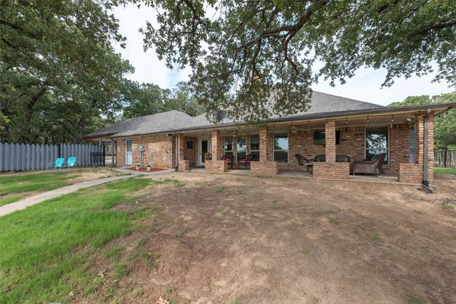 Back of house featuring brick siding, fence, and a lawn | Image 25