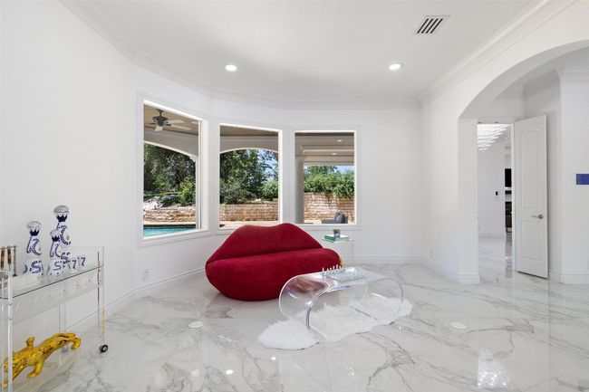 Sitting room featuring arched walkways, crown molding, marble tiled floors, baseboards, and recessed lighting | Image 7