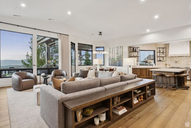 Living room featuring light wood-style floors, lofted ceiling, recessed lighting, and a mountain view | Image 13
