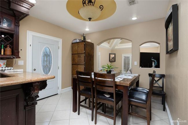 Dining space with beam ceiling, light tile patterned floors, and coffered ceiling | Image 4