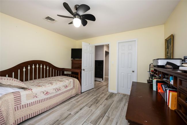 Bedroom featuring ceiling fan and a baseboard heating unit | Image 15