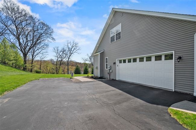 A side entry garage provides a level entry to the home. A large driveway provides a turn around space as well. | Image 49