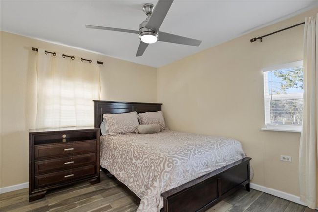 Bedroom featuring wood finished floors, a ceiling fan, and baseboards | Image 18