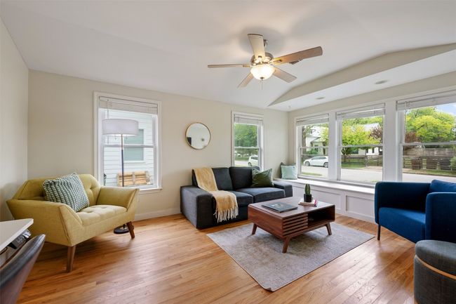Living room has lots of windows flooding the room with light. | Image 4