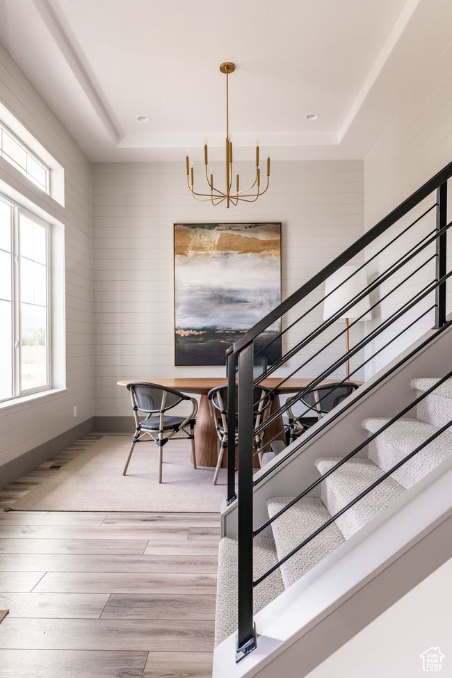 Dining area with a raised ceiling, hardwood / wood-style flooring, and a notable chandelier | Image 5