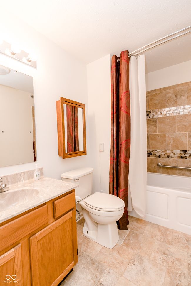 bathroom featuring shower / bath combo with shower curtain, vanity, and toilet | Image 22