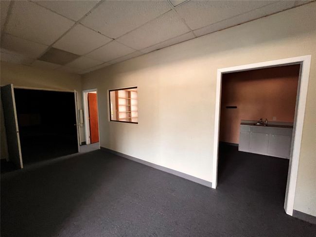 Spare room with a paneled ceiling, baseboards, and dark carpet | Image 10