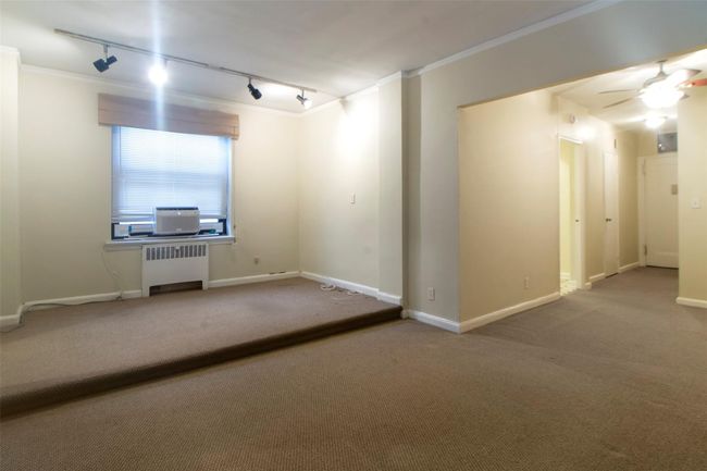 Unfurnished room featuring rail lighting, carpet floors, ornamental molding, radiator heating unit, and a ceiling fan | Image 5