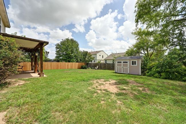 Fenced backyard with a storage unit and a patio area | Image 31