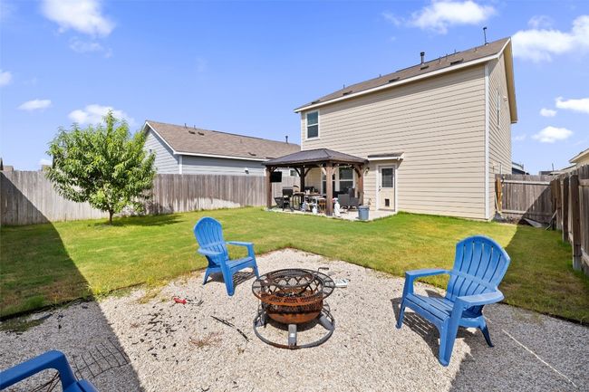 Rear view of house featuring a fire pit, a gazebo, a patio, and a fenced backyard | Image 17