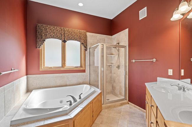 Private owners bath with jet tub, double vanity and lovely tiled shower. | Image 12